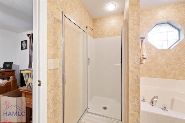 bathroom with shower with separate bathtub and a textured ceiling