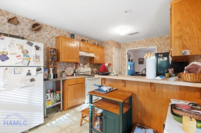 kitchen featuring a kitchen breakfast bar, white appliances, kitchen peninsula, and light tile patterned floors