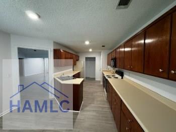 kitchen with light countertops, recessed lighting, light wood-style flooring, and a textured ceiling