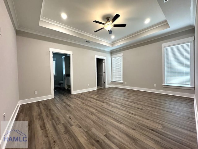 193W Melody Dr, Jesup, GA 31545 - unfurnished bedroom featuring a raised ceiling, ornamental molding, dark wood-style flooring, a spacious closet, and ensuite bath
