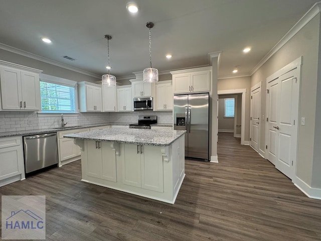 193W Melody Dr, Jesup, GA 31545 - kitchen featuring appliances with stainless steel finishes, crown molding, white cabinets, a kitchen island, and dark wood-type flooring