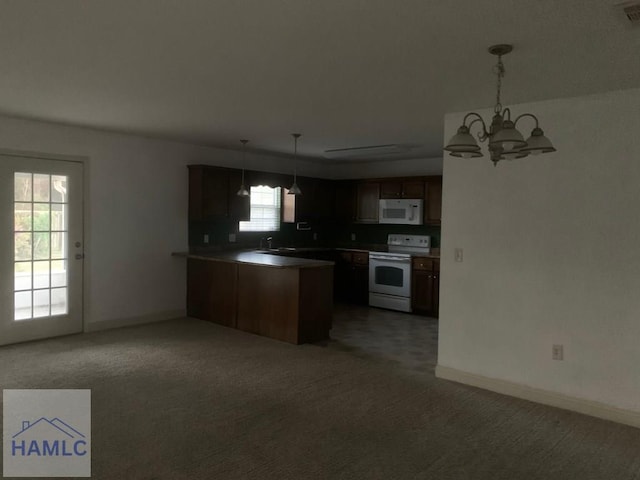 kitchen featuring kitchen peninsula, white appliances, sink, decorative light fixtures, and an inviting chandelier