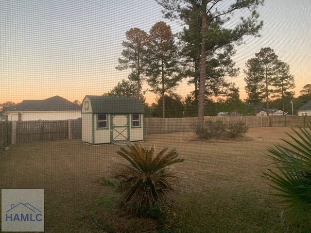 yard at dusk featuring a shed