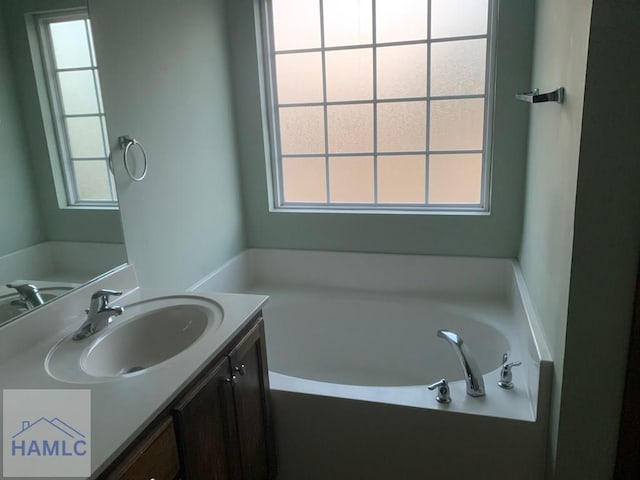 bathroom with vanity, a tub to relax in, and a wealth of natural light