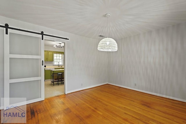 265 Mahan St, Jesup, GA 31545 - unfurnished dining area with light wood-type flooring and a barn door