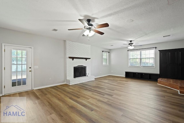 265 Mahan St, Jesup, GA 31545 - unfurnished living room featuring ceiling fan, wood finished floors, a textured ceiling, and a fireplace