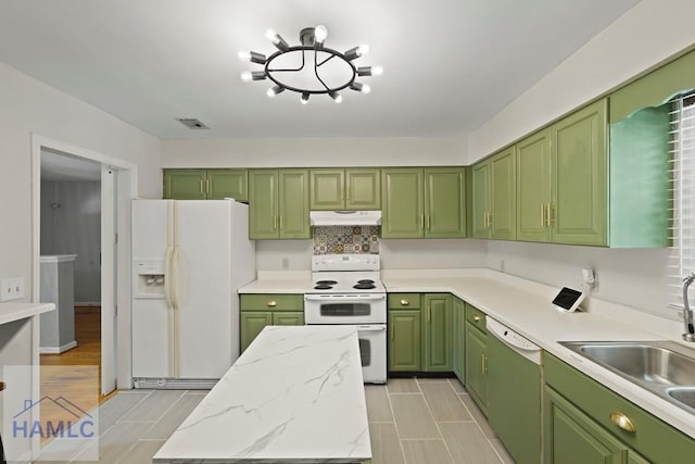 265 Mahan St, Jesup, GA 31545 - kitchen featuring white appliances, green cabinetry, under cabinet range hood, light stone countertops, and decorative backsplash