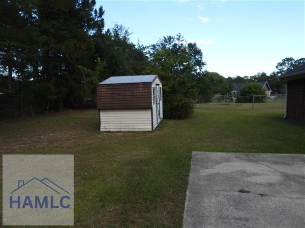 1111 Apache Aly, Hinesville, GA 31313 - view of grassy yard featuring a storage shed
