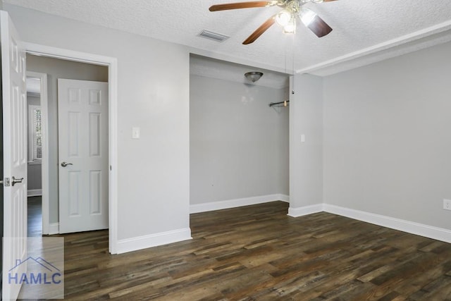 empty room featuring visible vents, a ceiling fan, a textured ceiling, wood finished floors, and baseboards