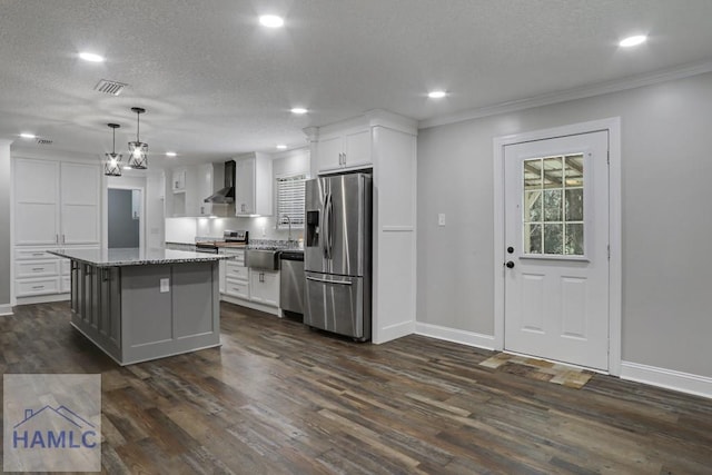 kitchen with dark wood-type flooring, wall chimney range hood, stainless steel appliances, white cabinets, and a textured ceiling