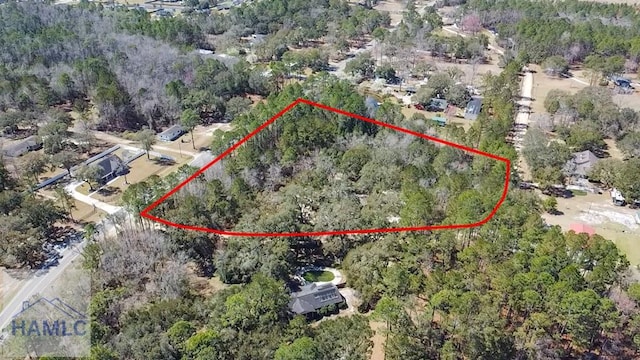 birds eye view of property featuring a view of trees