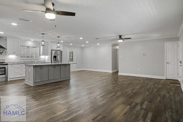 kitchen with a center island, visible vents, stainless steel appliances, and dark wood-style floors