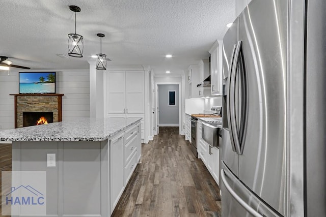 kitchen featuring a kitchen island, dark wood-style floors, open floor plan, appliances with stainless steel finishes, and white cabinets