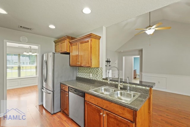 138 Forest St NE, Ludowici, GA 31316 - kitchen featuring stainless steel appliances, dark countertops, a ceiling fan, a peninsula, and light wood-type flooring
