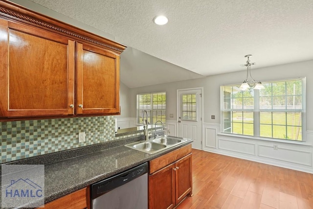 138 Forest St NE, Ludowici, GA 31316 - kitchen with stainless steel dishwasher, a textured ceiling, dark countertops, light wood-type flooring, and hanging light fixtures