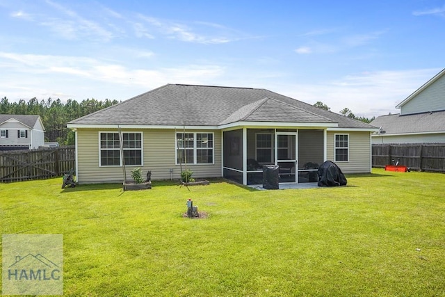 138 Forest St NE, Ludowici, GA 31316 - back of property with a fenced backyard, a sunroom, and roof with shingles