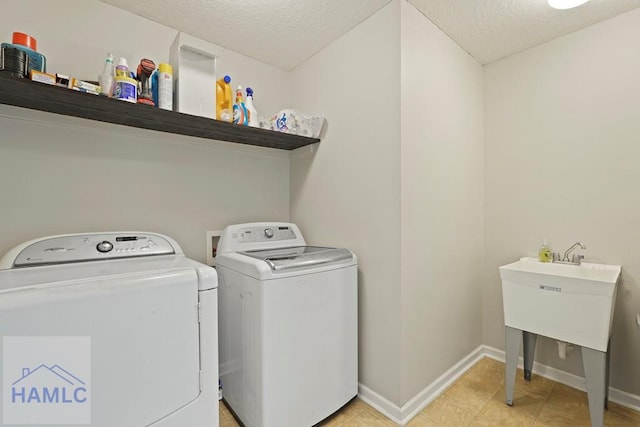138 Forest St NE, Ludowici, GA 31316 - laundry room featuring washing machine and clothes dryer, a textured ceiling, and light tile patterned floors