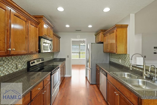 138 Forest St NE, Ludowici, GA 31316 - kitchen with stainless steel appliances, dark wood-type flooring, brown cabinetry, tasteful backsplash, and recessed lighting