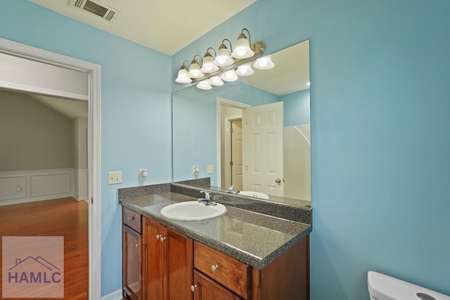 138 Forest St NE, Ludowici, GA 31316 - bathroom with vanity, wood finished floors, and wainscoting