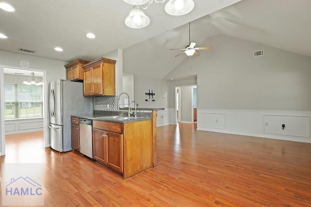 138 Forest St NE, Ludowici, GA 31316 - kitchen with appliances with stainless steel finishes, brown cabinets, open floor plan, light wood-type flooring, and a ceiling fan