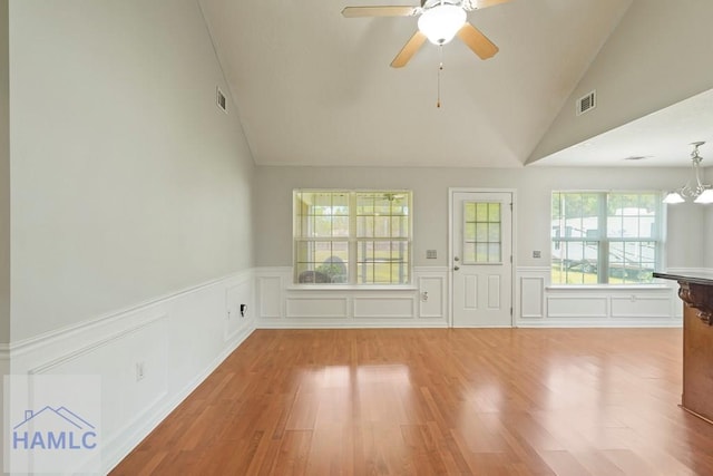 138 Forest St NE, Ludowici, GA 31316 - unfurnished living room featuring light wood-style flooring, a wainscoted wall, ceiling fan, a decorative wall, and high vaulted ceiling