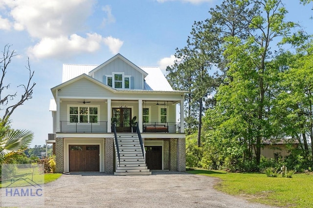 coastal home featuring stairway, ceiling fan, aphalt driveway, and an attached garage