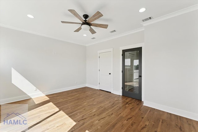 unfurnished room with ceiling fan, visible vents, baseboards, ornamental molding, and wood finished floors