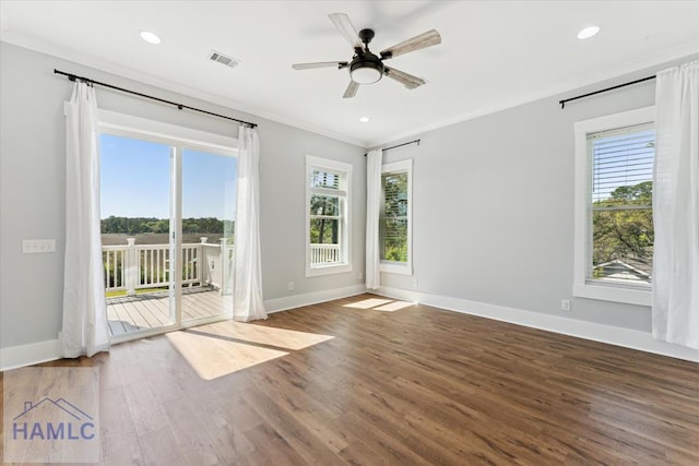 empty room with visible vents, wood finished floors, and baseboards