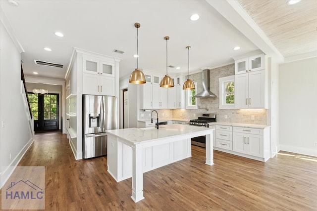 kitchen with stainless steel appliances, tasteful backsplash, crown molding, wall chimney exhaust hood, and baseboards
