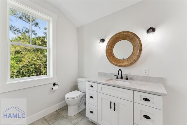 bathroom featuring vanity, tile patterned floors, toilet, baseboards, and lofted ceiling
