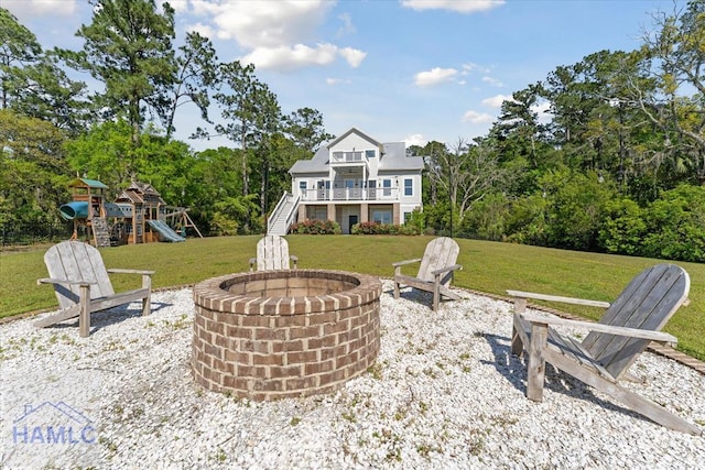 view of patio / terrace with stairway, an outdoor fire pit, a balcony, and a playground
