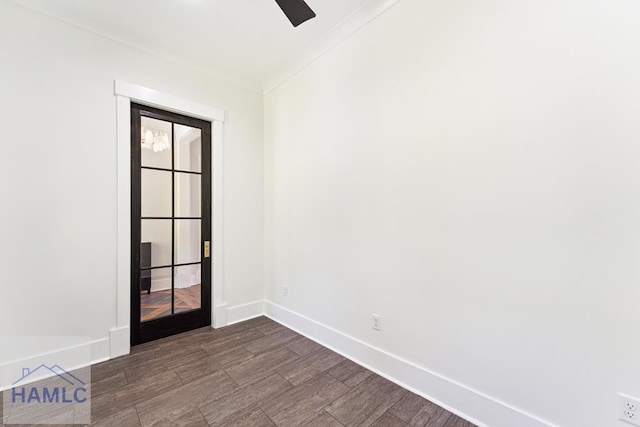 spare room featuring a ceiling fan, ornamental molding, dark wood-style floors, and baseboards