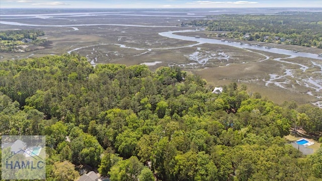 birds eye view of property with a water view and a wooded view