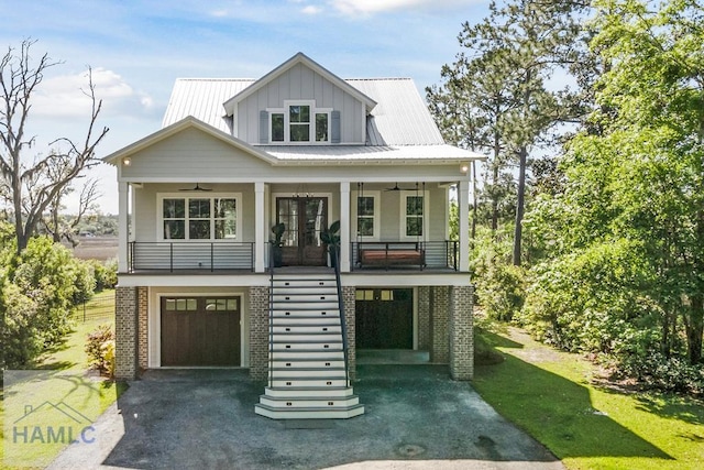 beach home with board and batten siding, covered porch, stairway, ceiling fan, and french doors