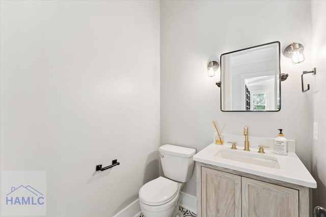 bathroom featuring vanity, toilet, and baseboards