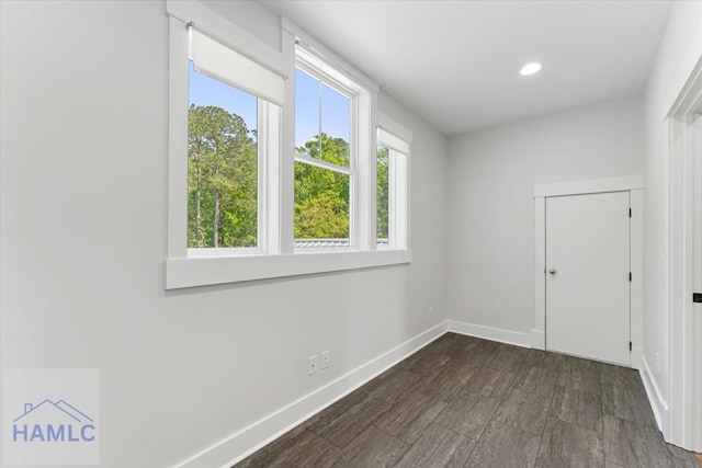 empty room featuring baseboards, recessed lighting, and dark wood-style floors