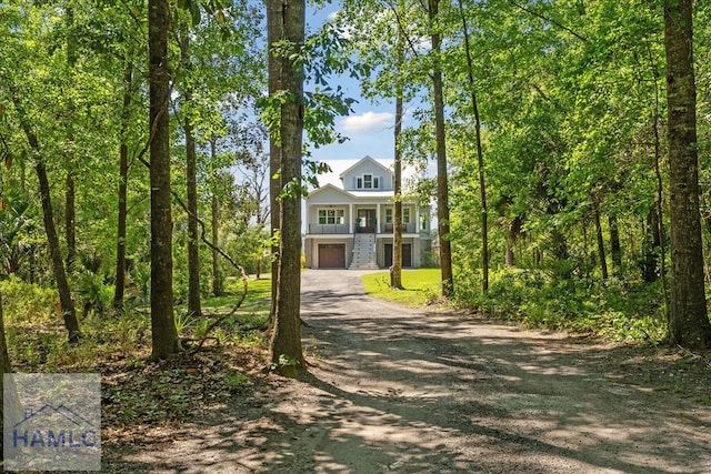 view of front of house with aphalt driveway, stairs, and an attached garage