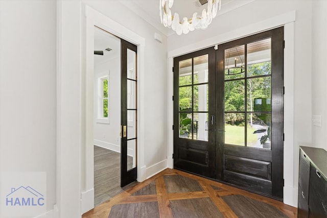 entryway featuring a wealth of natural light, french doors, a notable chandelier, and baseboards