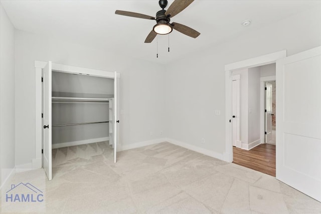 unfurnished bedroom with a closet, baseboards, a ceiling fan, and light carpet