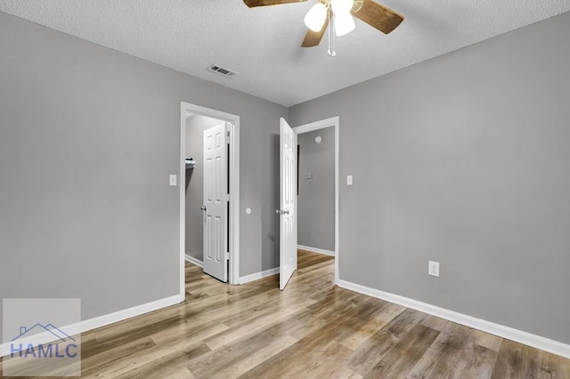 unfurnished bedroom with ceiling fan, a textured ceiling, and light wood-type flooring