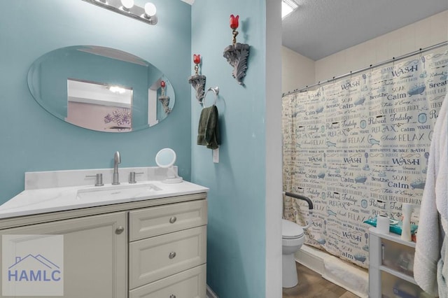 bathroom with a shower with curtain, hardwood / wood-style floors, a textured ceiling, toilet, and vanity