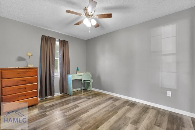 unfurnished bedroom featuring hardwood / wood-style flooring, ceiling fan, and a textured ceiling