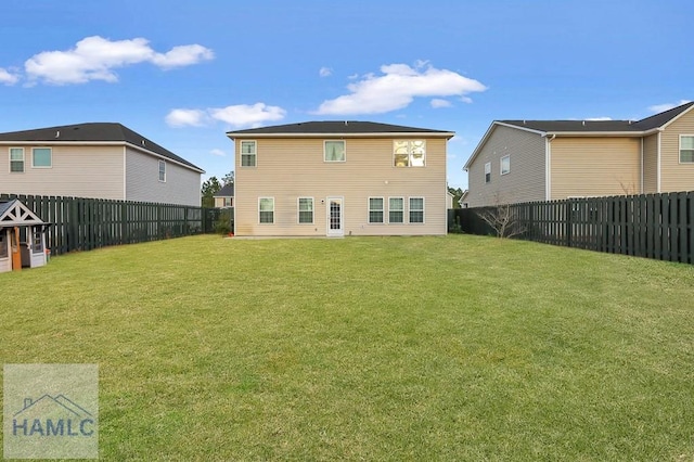 back of house featuring a yard and a fenced backyard