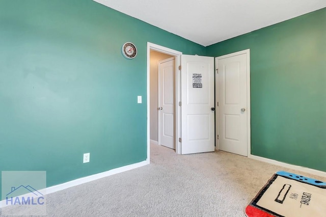 unfurnished bedroom featuring baseboards and carpet flooring