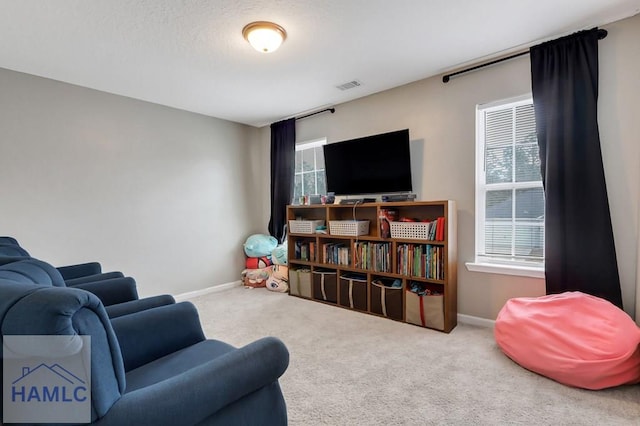 interior space featuring carpet floors, a healthy amount of sunlight, visible vents, and baseboards