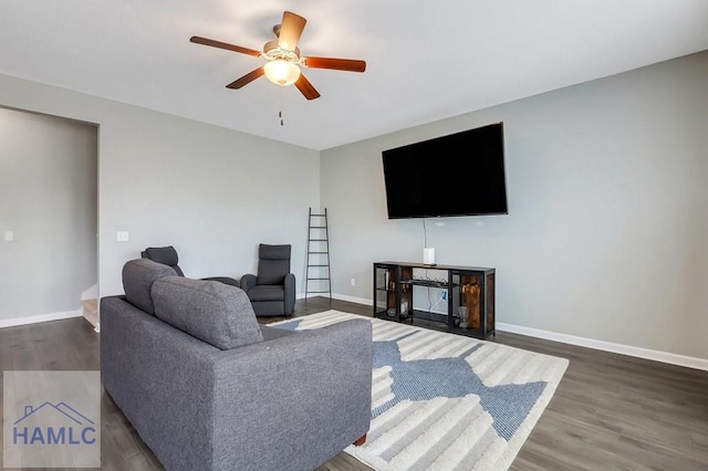 living room featuring baseboards, a ceiling fan, and wood finished floors