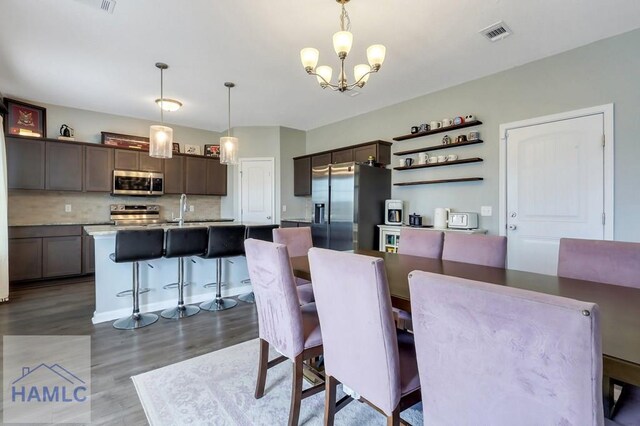 dining room with a chandelier, dark wood-type flooring, and visible vents