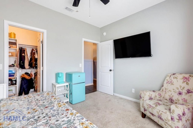 bedroom with carpet flooring, visible vents, a spacious closet, a ceiling fan, and a closet