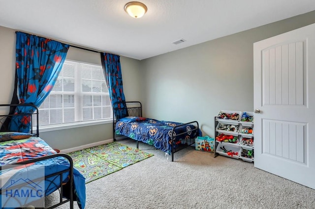 bedroom with baseboards, visible vents, and carpet floors