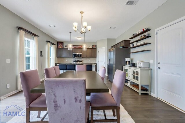 dining area featuring baseboards, dark wood-style flooring, a chandelier, and visible vents